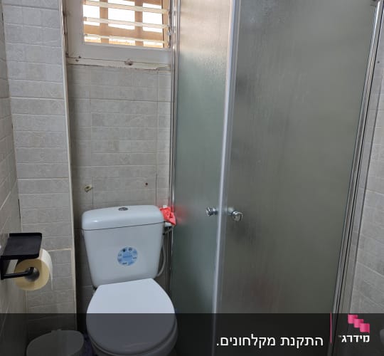 מקלחון עם דלת זכוכית חלבית בחדר אמבטיה